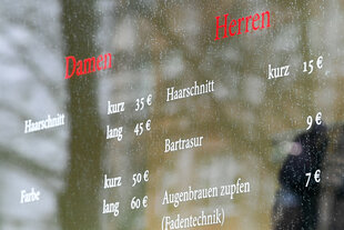 Schild mit den Preisen eines Friseursalons