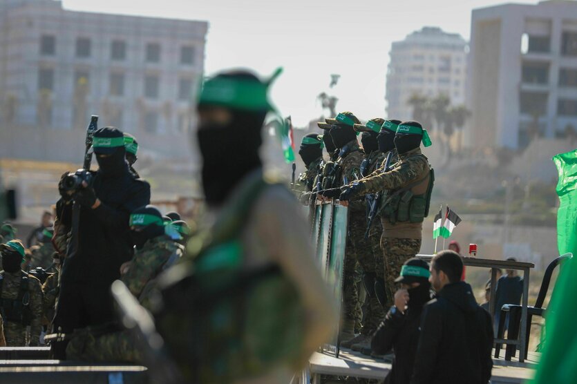 Hamas-Kämpfer stehen am Ort der Übergabe einer Geisel an das Rote Kreuz in der Stadt Gaza