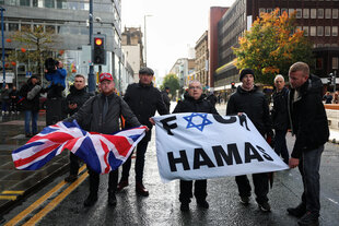 Demonstrantierende halten eine britische Flagge und ein Banner mit der Aufschrift 