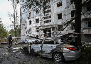 Zerstörtess Auto und Wohnhaus in Saporischschja