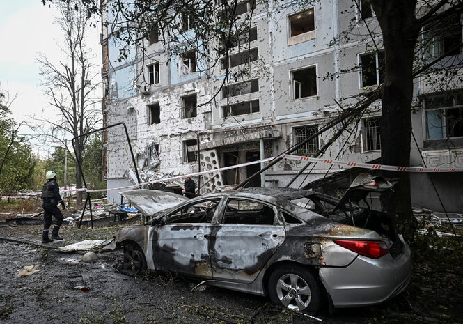 Zerstörtess Auto und Wohnhaus in Saporischschja