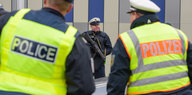 Deutsche und französische Polizisten am Sonntag an der Grenze bei Saarbrücken im Einsatz. Dazu ein dritter Polizist mit Maschinengewehr im Hintergrund