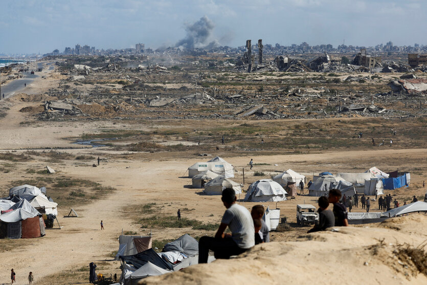 Palästinenser beobachten den Rauch, der nach Explosionen in Gaza-Stadt aufsteigt, gesehen vom zentralen Gazastreifen aus