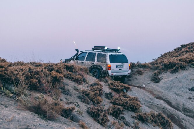 Ein Auto in einer Sanddüne auf Offroadkurs in Rückansicht.