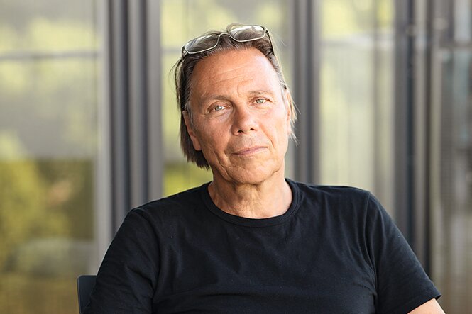 Der Soziologe Harald Welzer sitzt in einem schwarzen T-Shirt, im Hintergrund Fenster.