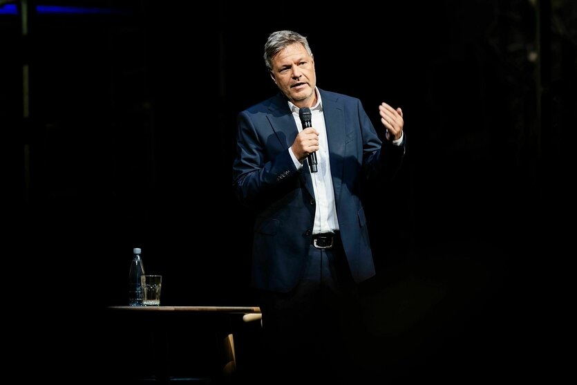 Robert Habeck steht auf einer Bühne und spricht in ein Mikrofon