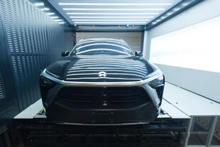 Eine Autokaroosserie ohne Räder liegt in einer metallenen Garage