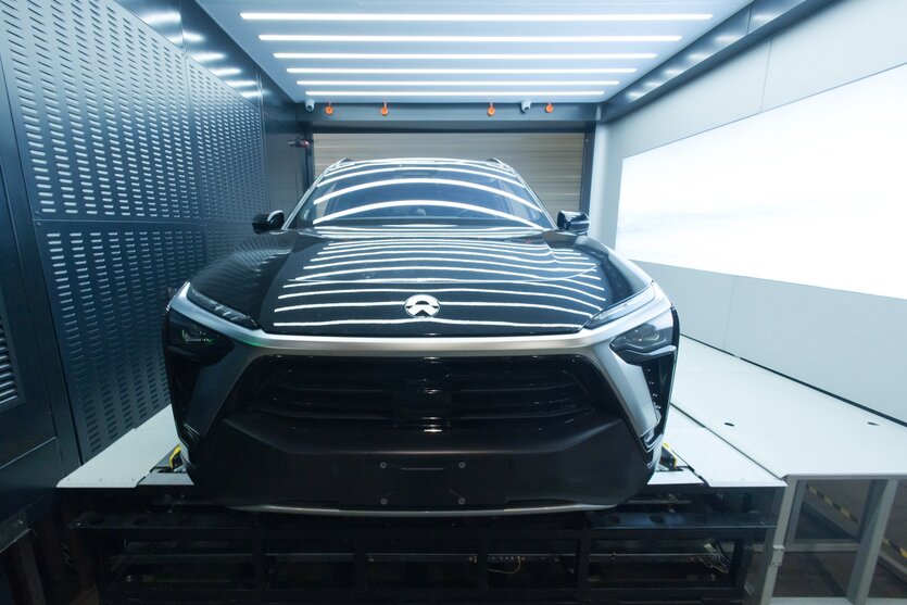 Eine Autokaroosserie ohne Räder liegt in einer metallenen Garage
