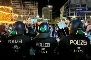 Eine Polizeikette steht vor pro-palästinensischen Demonstranten am Alex