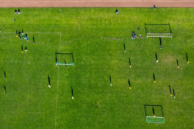 Fußballfeld mit Spielern drauf aus der Vogelperspektive fotografiert