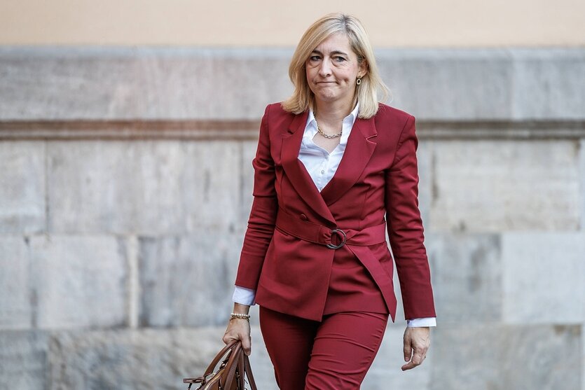 Nina Warken schaut skeptisch und trägt eine Aktentasche in de Händen