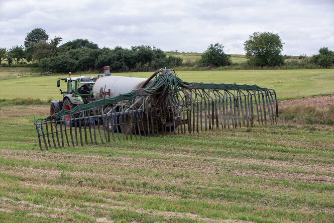 Ein Traktor mit einem Gülletank auf einem Feld