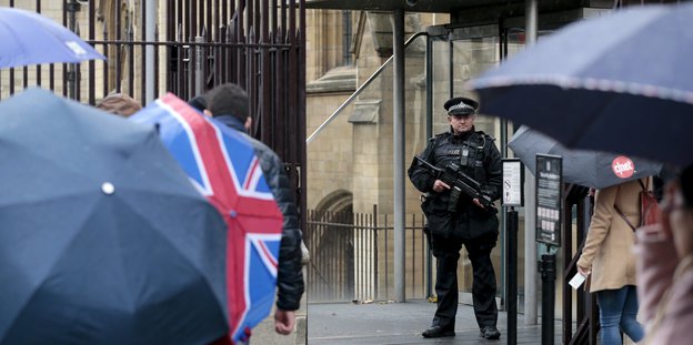 Ein bewaffneter Polizist steht vor dem Eingang zum Britschen Parlament