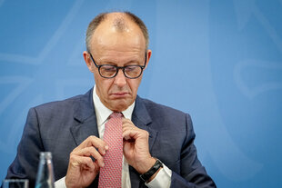 Merz richtet seine Krawatte