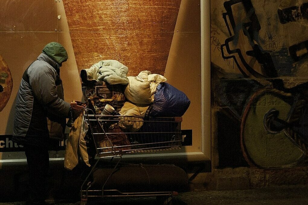 Obdachlose Person mit einem Einkaufswagen voller Habseligkeiten