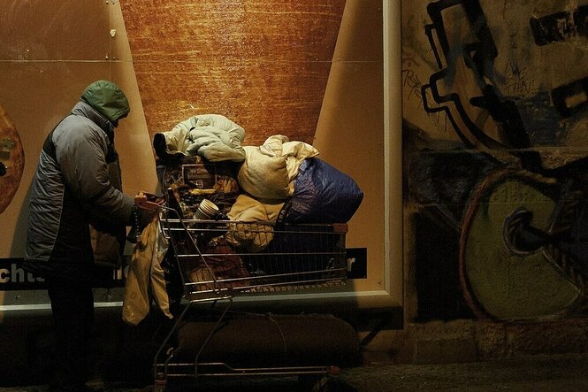 Obdachlose Person mit einem Einkaufswagen voller Habseligkeiten