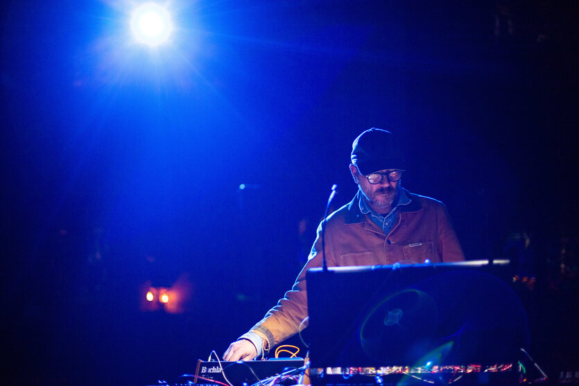 Sam Prekop live bei einem Konzert in New York, April 2025. Hinter ihm leuchtet ein greller Bühnenscheinwerfer