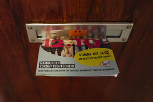Ein Werbezettel des Hamburger Zukunftsentscheids hängt in einem Briefkasten