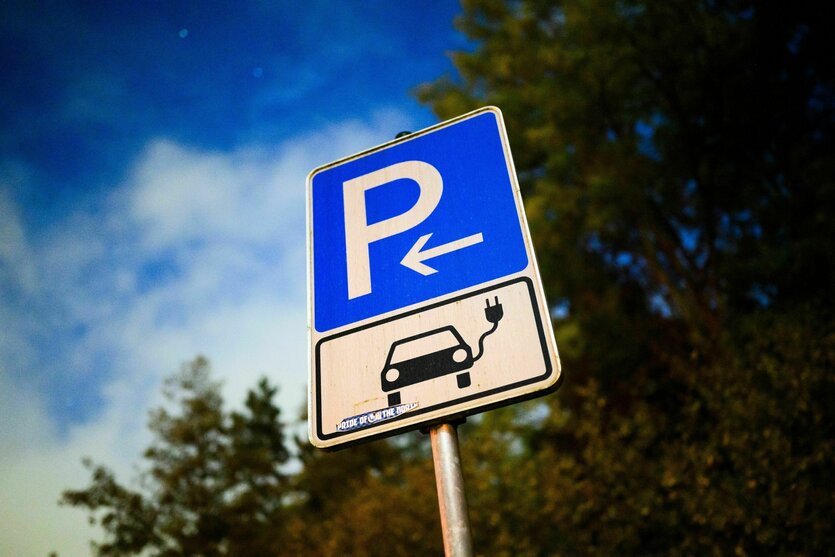 Ein Schild markiert einen Parkplatz für ein Elektroauto an einer öffentlichen Schnellladesäule.