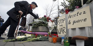Ein Mann legt vor der französischen Botschaft in Moskau Blumen für die Opfer der Anschläge nieder.
