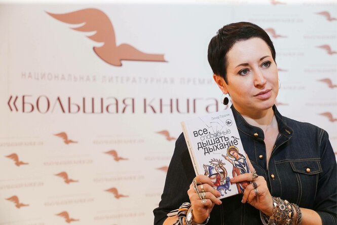 Eine Frau hält ein Buchcover in die Kamera