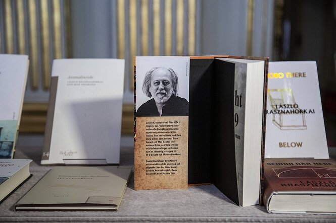 Bücher des Literaturnobelpreisträgers Laszlo Krasznahorkai, eines ist aufgeschlagen in der Buchklappeist ein portraitfoto des Autoren zu sehen