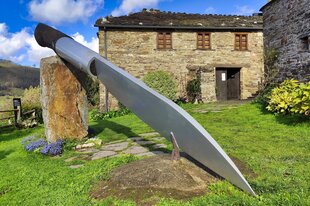 Das Modell eines riesigen Messers vor einem alten Haus