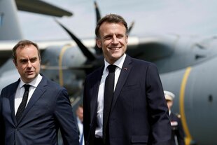 Lecornu und Macron, im Hintergrund ist ein Militärflugzeug zu sehen