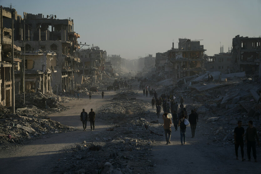 Vertriebene Palästinenser tragen ihre Habseligkeiten, während sie die stark beschädigte Al-Jalaa-Straße in Gaza-Stadt entlanggehen