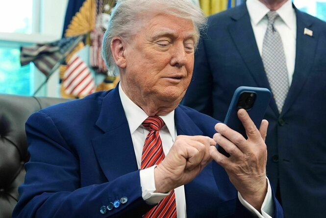 Donald Trump im Oval Office mit einem Smartphone in der Hand