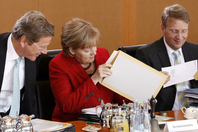 Angela Merkel mit Westerwelle und Pofalla und großem Briefumschlag
