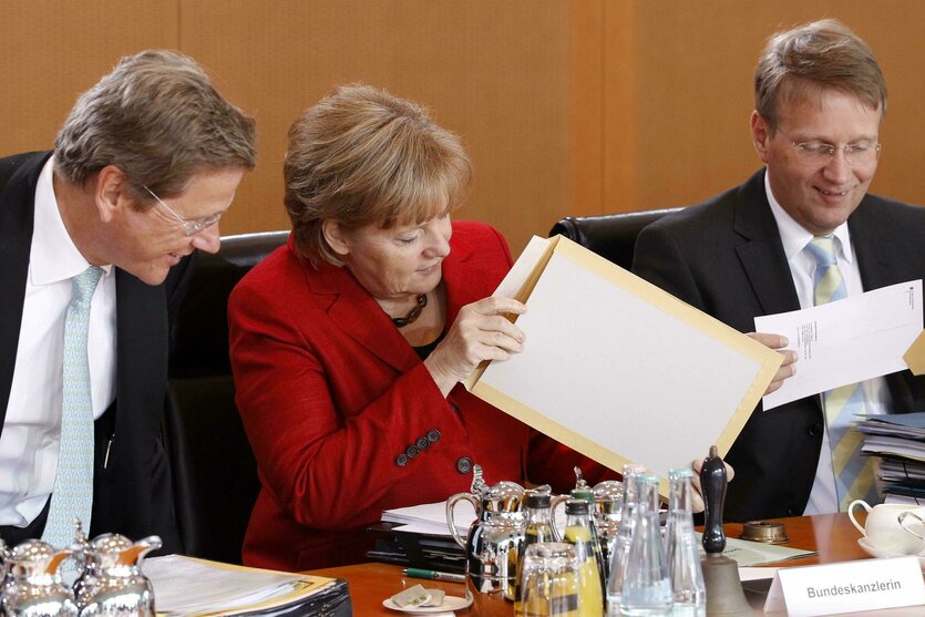 Angela Merkel mit Westerwelle und Pofalla und großem Briefumschlag