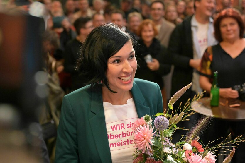 Potsdams neue Oberbürgermeisterin hält lächelnd einen Blumenstrauß nach ihrem Wahlsieg
