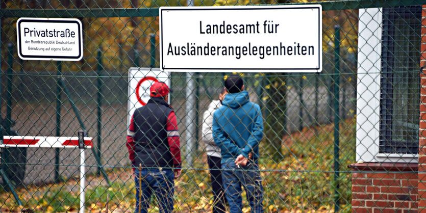 Flüchtlinge stehen vor einer Kaserne, die zur Erstaufnahmeeinrichtung umfunktioniert wurde