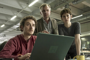 Drei Personen schauen in einen Laptop