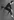 Merce Cunningham bei einem Sprung in die Luft, ein Stuhl ist an seinen Rücken gebunden