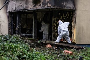 Einsatzkräfte der Spurensicherung stehen in einer ausgebrannten Wohnung in Berlin-Neukölln. Bei dem Brand wurden zahlreiche Menschen verletzt.