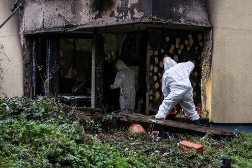 Einsatzkräfte der Spurensicherung stehen in einer ausgebrannten Wohnung in Berlin-Neukölln. Bei dem Brand wurden zahlreiche Menschen verletzt.
