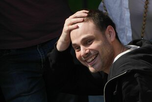 Ein junger Mann greift sich an die Stirn