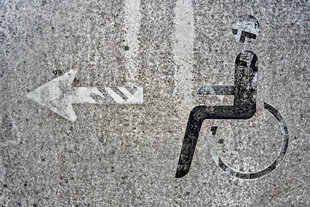 Ein verwittertes Rollstuhlfahrer-Symbol.
