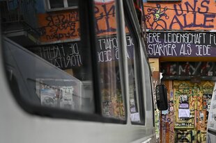 Ein Auto vor dem bunt bemalten Eingang der Rigaer 94