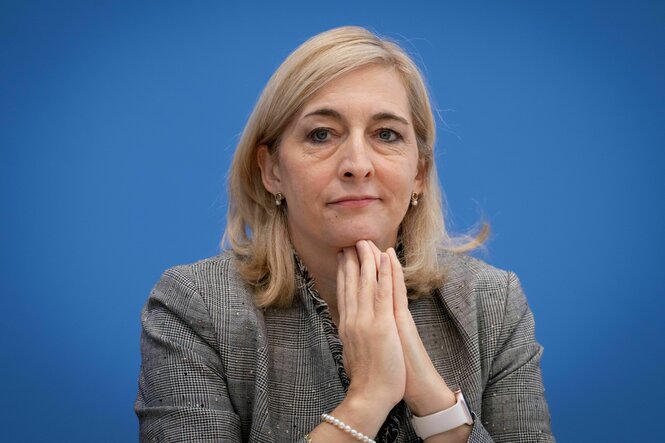 Eine Frau hält ihre Hände unter ihr Kinn