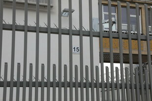 Ein Gitterzaun vor einer Hausfassade