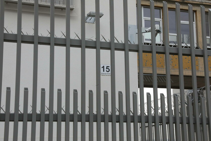 Ein Gitterzaun vor einer Hausfassade