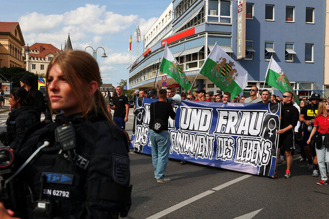 Menschen demonstrieren mit einem Transparent, darauf ist der Spruch "Mann und Frau - das Fubndament des Lebns zu lesen