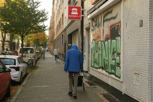 Straße in Hamburg - ein Mann schiebt seinen Hackenporsche vor sich her, der Kiosk ist geschlossen, wenig Menschen auf der Straße