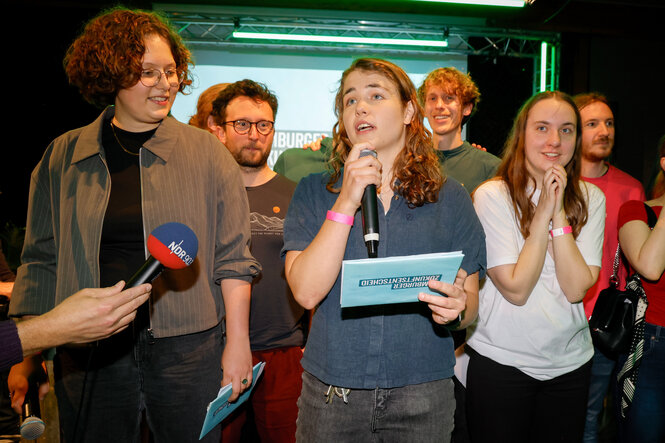 Annika Rittmann (M), Fridays for Future., spricht neben Lou Töllner (l), eine der Vertrauensperson der Initiative im Senat, und Annika Kruse (M, r), Fridays for Future, in dem Lokal in dem die Wahlparty der Initiative «Hamburger Zukunftsentscheid»
