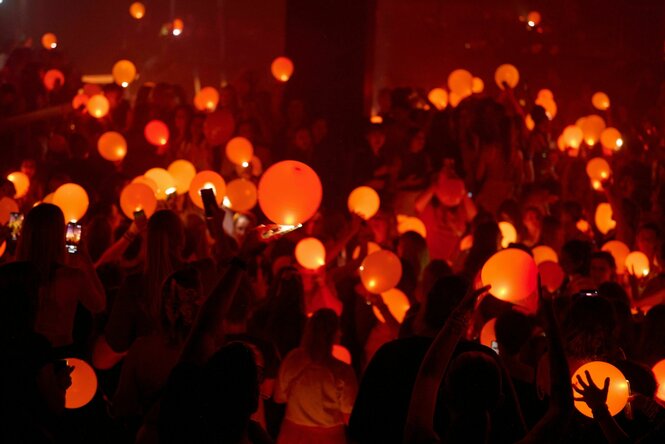 Menschen auf einer Party tanzen im orangerotem Licht