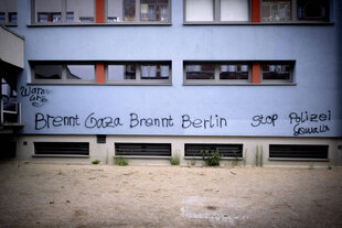 Graffiti mit Parole "Brennt Gaza Brennt Berlin" und "Stop Polizeigewalt" auf der Fassade von einer Schule in Tiergarten