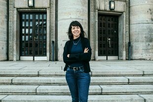 Porträt von Elif Eralp - sie steht vor der Volksbühne in Berlin